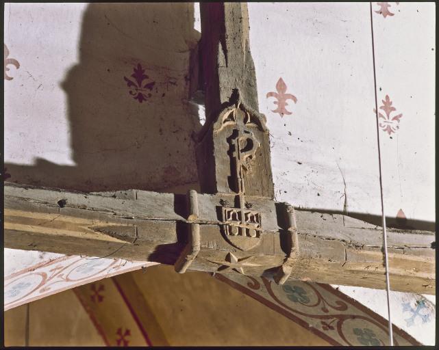 Décor de l'entrait et du poinçon de la ferme à la limite de la nef et du choeur : étoile et armes des Taveau.