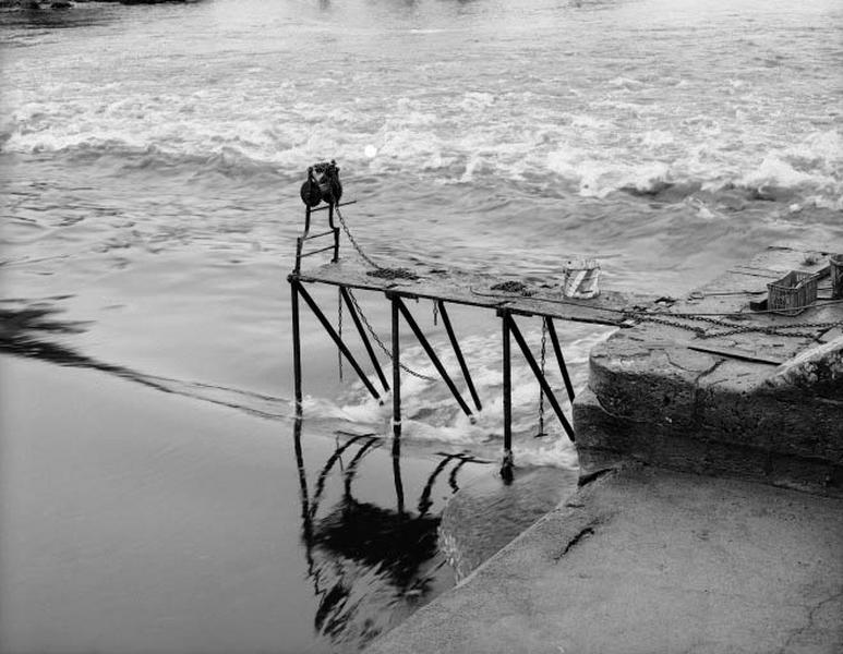 Les trois premières fermettes sont relevées. Le sable qui se trouve dans le seau est jeté sur la passerelle métallique de chaque fermette nouvellement sortie de l'eau (pour éviter de glisser).