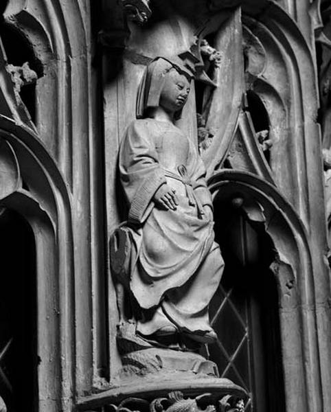 Deuxième travée sud, petit contrefort de jonction entre la première et la deuxième sections, étage inférieur : femme assise sur un animal (chien ?), coiffée d'une templette.