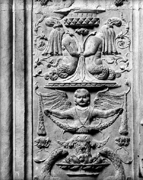 Neuvième travée nord, deuxième section, encadrement droit : décor de candélabre, un putto végétal présente un feston. Au-dessus, deux personnages fabuleux, la tête voilée et à queue de serpent sont opposés.