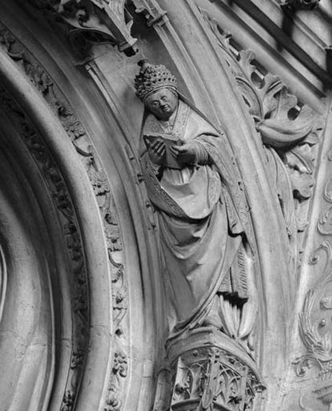 Troisième travée sud, claire-voie de la troisième section, arc en anse de panier soulignant l'ancienne ouverture sur le choeur, côté droit : pape ou saint Pierre en haut-relief sur une console portant la tiare et lisant.