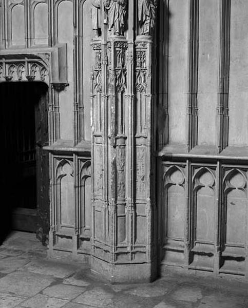 Quatorzième travée nord, quatrième section, ancienne porte d'accès à la chapelle Saint-Jean l'Evangéliste et partie inférieure du contrefort de jonction avec la quinzième travée : décor de fenestrage et de candélabres, épis de blé, ornementation végétale, oiseaux fabuleux et faunes enfants.