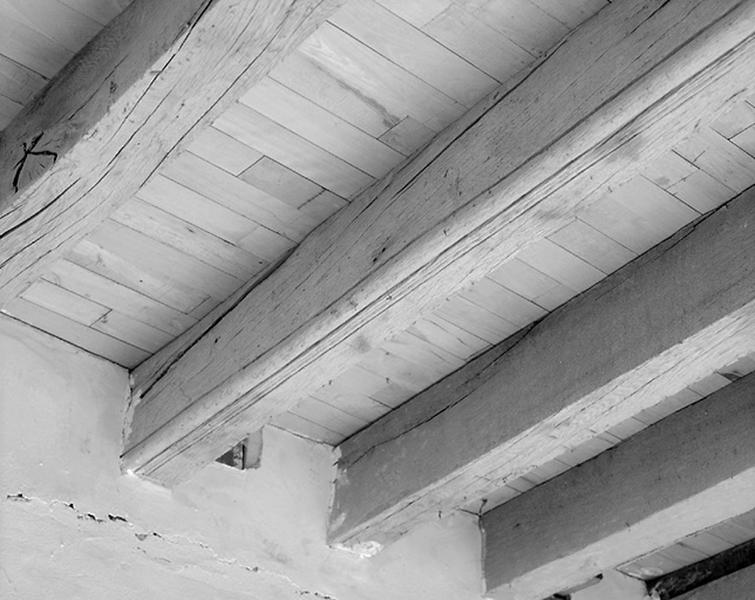 Vue intérieure de l'étage.Détail d'une poutre moulurée du plafond.