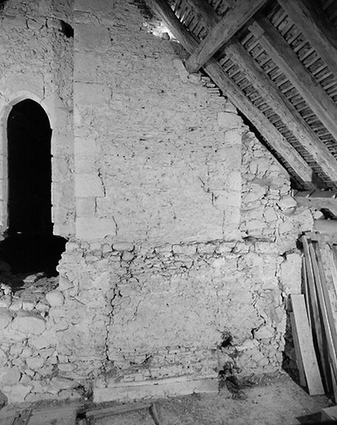 Vue intérieure du comble. Vestiges de la construction médiévale et face externe d'une porte en arc brisé.