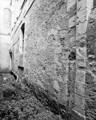 Baie géminée romane bouchée au rez-de-chaussée de la façade ouest du corps de bâtiment perpendiculaire à la collégiale.