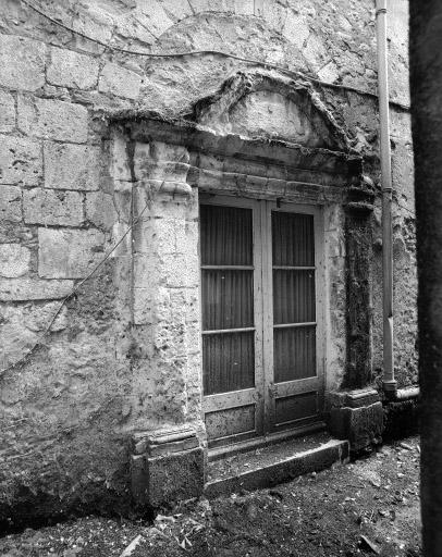 Porte du rez-de-chaussée de la façade ouest du corps de bâtiment perpendiculaire à la collégiale et arc d'une ancienne porte romane (?).