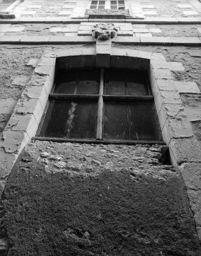 Baie partiellement bouchée avec reste du croisillon de bois d'origine au rez-de-chaussée de la façade ouest du corps de bâtiment perpendiculaire à la collégiale.