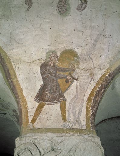 Homme armé d'une épée et d'un bouclier luttant contre un lion. 1ère colonne nord, face est.