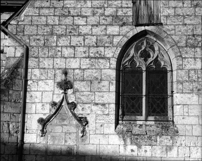 Vue de détail de la baie de la chapelle sud et du gâble en accolade d'une ancienne porte.