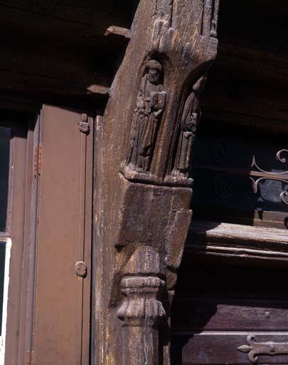 Tête du poteau central de droite représentant Saint Pierre à gauche avec ses clefs et un livre et à droite Saint Paul avec son épée et un livre.