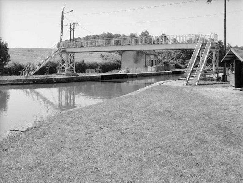 Passerelle métallique avec au fond la maison de garde de la Cognardière.