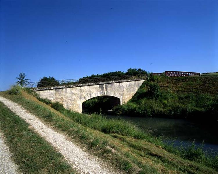 L'arche en pierre enjambe l'ancien canal et le pont métallique enjambe le nouveau canal.