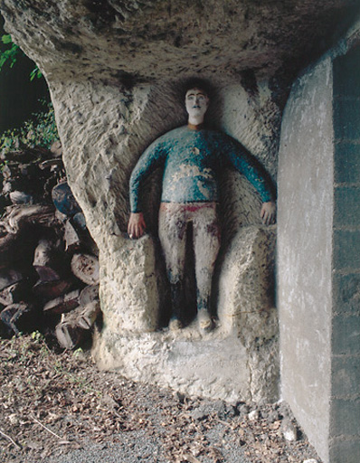 Sculptures ornant l'entrée de la cave. Vue d'ensemble du personnage situé à gauche de l'entrée.