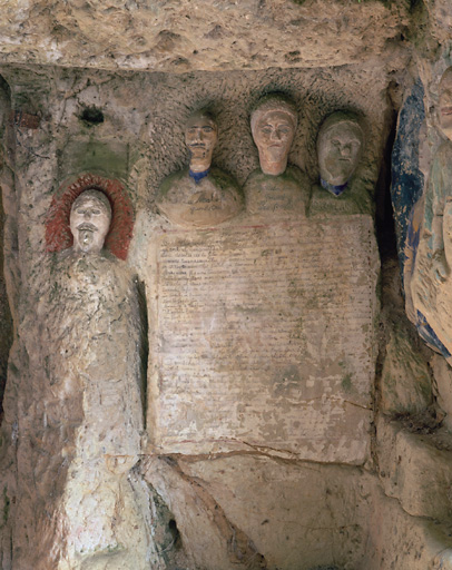 Sculptures ornant l'entrée de la cave. Vue d'ensemble des 3 bustes surmontant l'inscription, situés à droite de l'entrée.