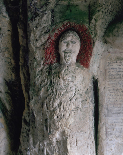 Sculptures ornant l'entrée de la cave. Détail. Tête située à gauche de l'inscription.