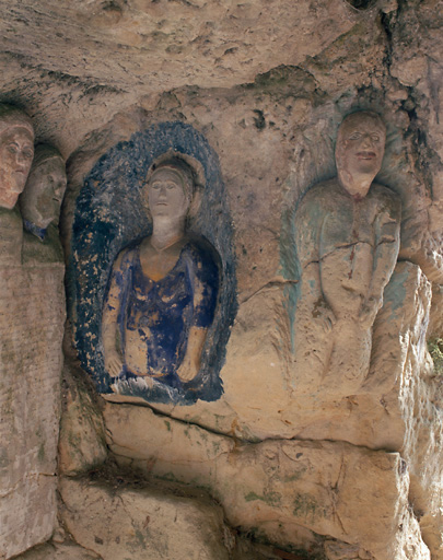 Sculptures ornant l'entrée de la cave. Figures à mi-corps situés à droite de l'inscription.