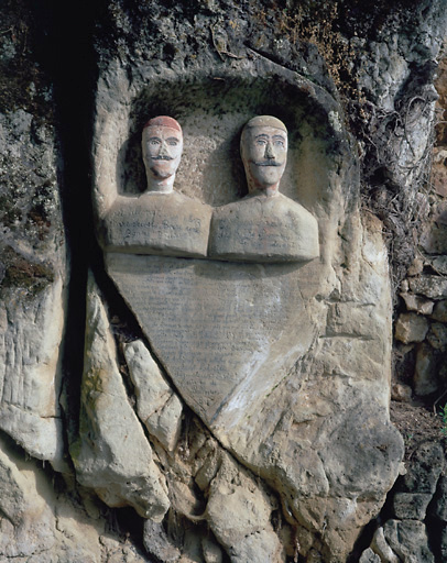 Sculptures ornant l'entrée de la cave. 2 bustes d'homme surmontant une inscription, situés dans la partie droite de l'entrée.