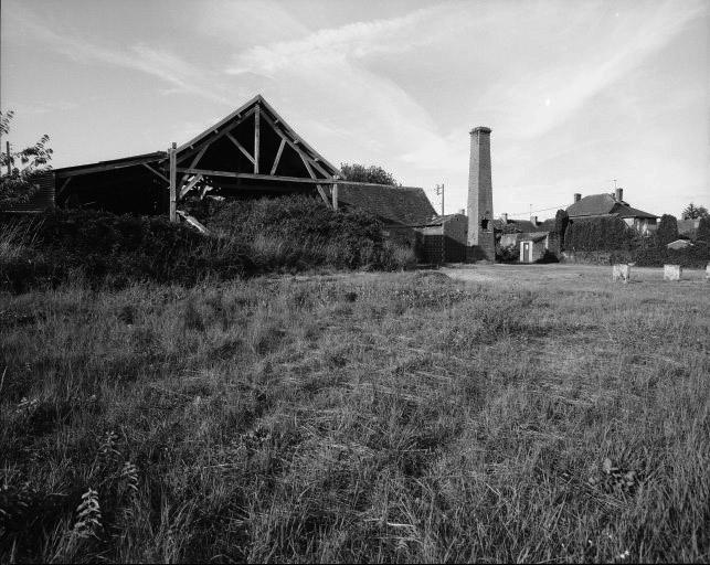 Vue d'ensemble du site au sud, avec à gauche le hangar du four, le bâtiment atelier-combustible, le bâtiment de rangement avec à l'avant la cheminée du four vetical détruit et à l'extrême droite les restes des supports maçonnés des poteaux d'une des halles.