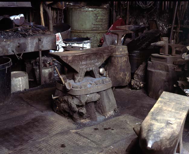 Enclume réalisée en 1898, vendue par René Germond. Elle pèse 195 kg et porte le n° de série 6551. Elle est fixée sur un billot de bois cerclé.