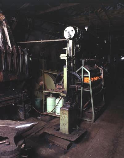 Différentes étapes de la fabrication du collet et de la douille d'une raclette. A gauche, le morceau de fer à partir duquel l'outil va être façonné. La mise d'acier sera introduite dans la refente.