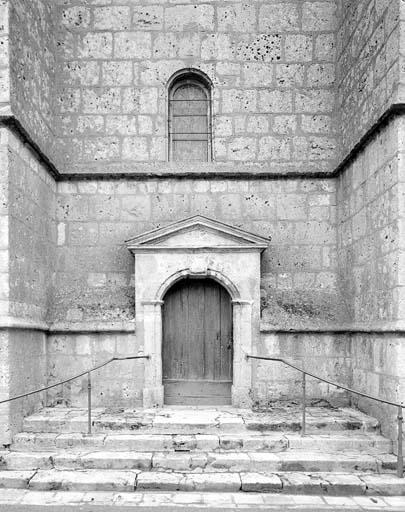 Vue de détail de la façade : porte de la tour du clocher.