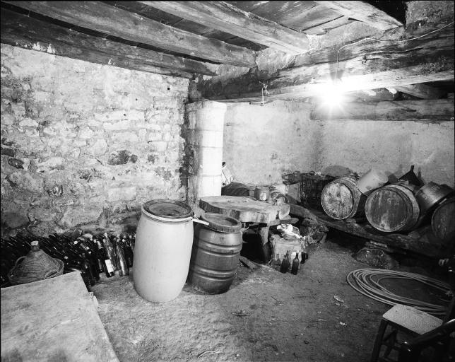Intérieur de la cave ; une des poutres maîtresses du plancher repose sur un pilier demi rond.