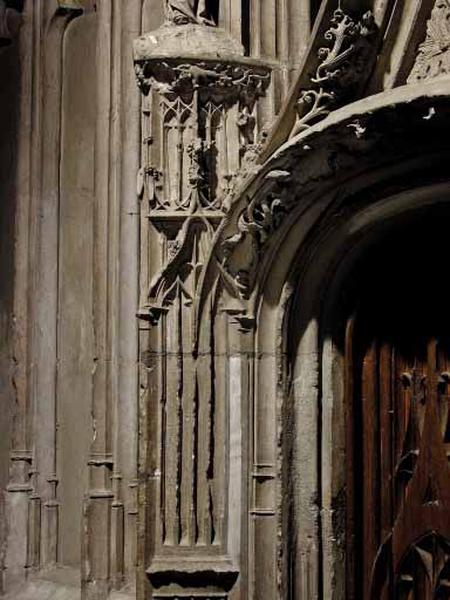 Première travée sud, deuxième section, encadrement de la porte, côté gauche : réseau de fenestrage dans lequel est inséré le départ de l'arc en anse de panier de la porte de la chapelle.