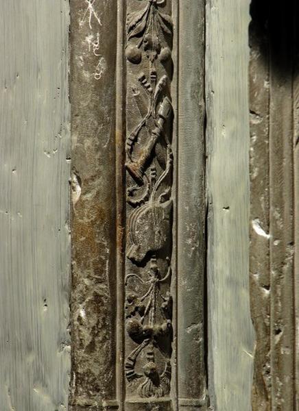 Quatrième travée sud, claire-voie de la première section, premier meneau, partie inférieure : détail de la chute d'objets, soufflet et deux chandeliers séparés par des bouquets de fleurs et entrelacés de rubans.