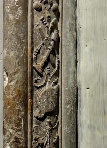 Quatrième travée sud, claire-voie de la première section, premier meneau : détail de la chute d'objets, soufflet et deux chandeliers entrelacés de rubans.