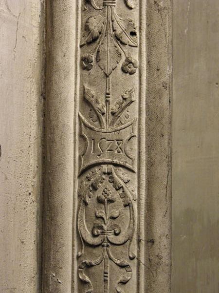 Dixième travée nord, claire-voie de la première section, deuxième meneau, retour gauche : détail d'une chute décorative, cartouche portant la date 1528.