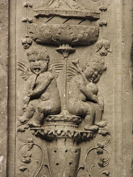 Onzième travée nord, pilastre de jonction entre les deux sections, retour droit : décor de candélabre, deux putti musiciens assis sur un vase jouent de la cornemuse et de la chalémie (vue rapprochée).