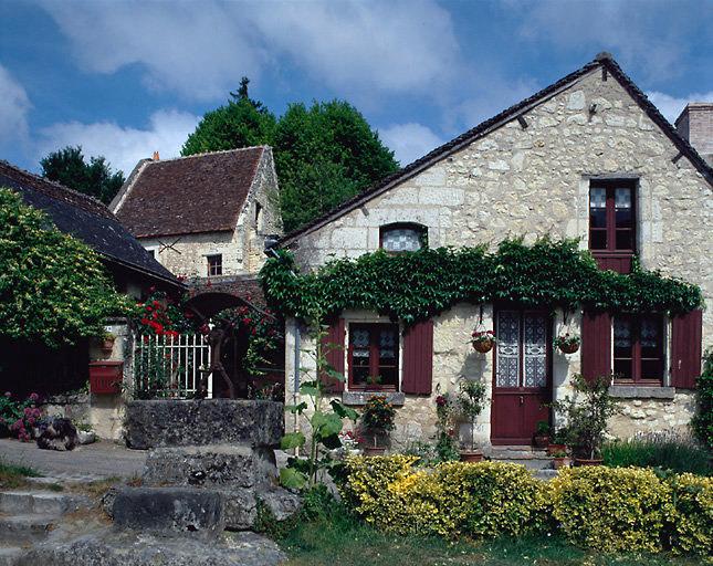 Maison du bourg bordant la place avec le puits.