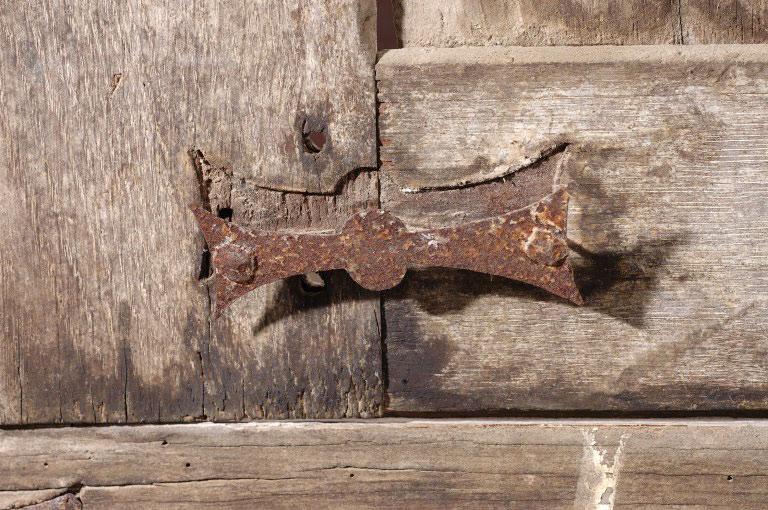 Ferrure renforçant l'assemblage d'un montant et d'une traverse, avec son emprunte dans le bois.