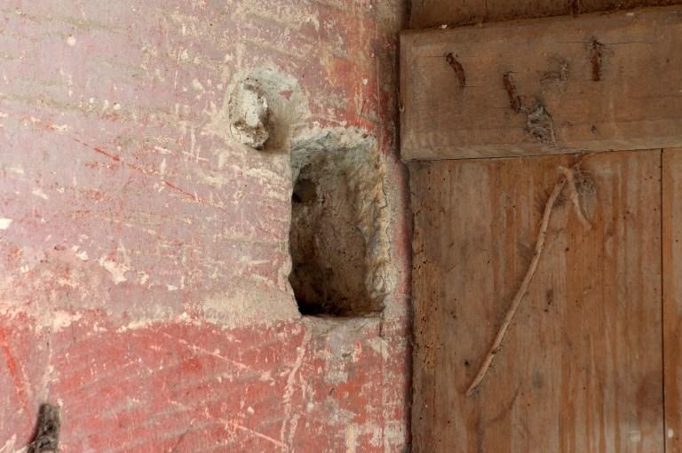 Grande salle du logis seigneurial. Détail du mur près d'une baie avec emplacement d'un système de fermeture.