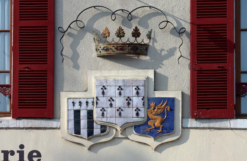 Les trois blasons associés surmontés de la couronne ducale : armoiries de la Bretagne ducale (au-dessus), Gwen ha du et blason symbolisant la France soumettant la Bretagne.
