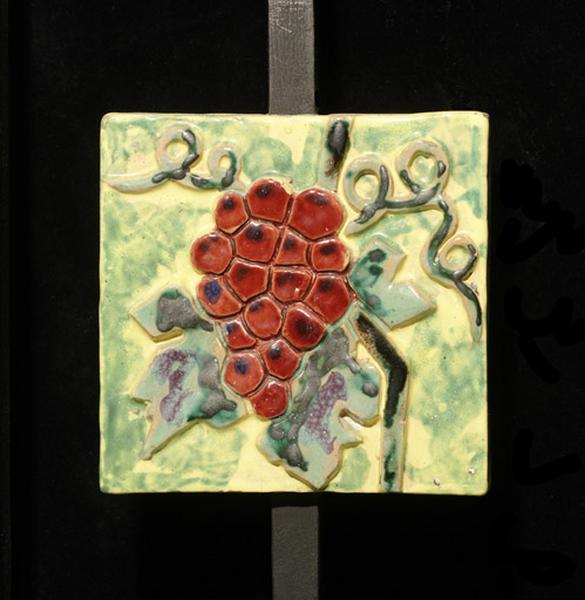 Plaque ornée d'une grappe de raisins.