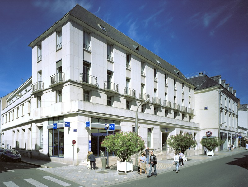 Vue générale à l'angle des rues Nationale et Etienne-Pallu. ; Façades ordonnancées de l'agence du Crédit Lyonnais, reconstruite dans la partie non sinistrée de la rue.