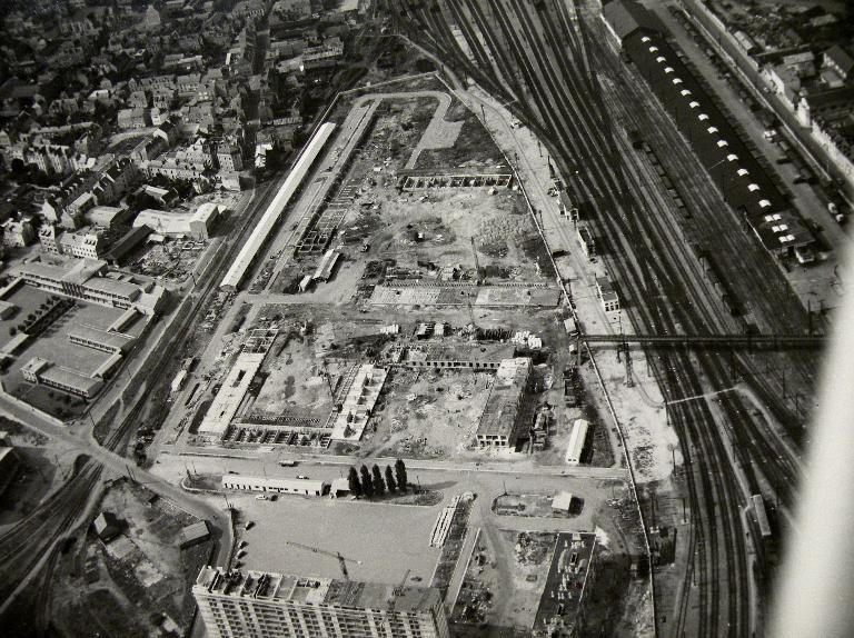 Vue de la construction de la partie Nord de la première tranche - 1958. (Archives communales de Tours, section contemporaine, Série Fi, cote 102Fi22). ; Vue de la construction de la partie nord de la première tranche - 1958. (Archives communales de Tours, section contemporaine, Série Fi, cote 102Fi22). ; Vue aérienne de la construction des immeubles H, I et J, au milieu à droite de la photo (le long des voies ferrées) - 1958. (Archives communales de Tours, section contemporaine, Série Fi, cote 102Fi22).