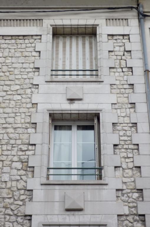 Détail de la façade principale : pointes de diamant, chaîne d'angle et jambes harpées.
