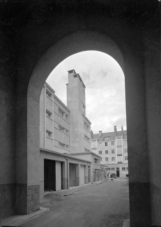 Vue du coeur de l'îlot M depuis le porche de la rue des Déportés, mars 1952. (archives municipales de Tours, Fonds Jacques et Thierry Germain, 114 Fi 189). ; Vu du coeur d'îlot depuis le porche monumental de la rue des Déportés, mars 1952. (archives municipales de Tours, Fonds Jacques et Thierry Germain, 114 Fi 189).