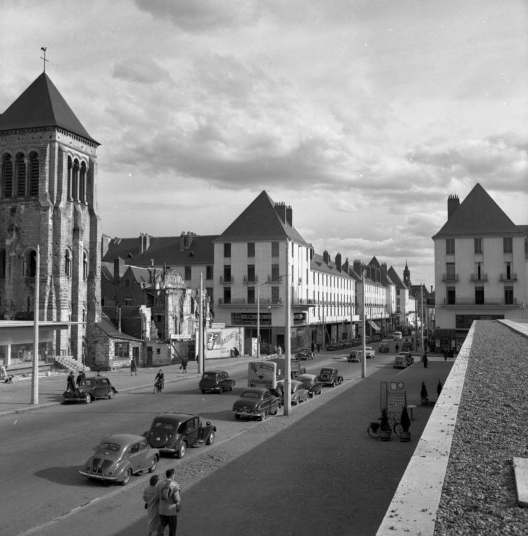 Vue de l'église Saint-Julien et de l'entrée de la rue Nationale depuis la terrasse ouest, 1956. (ministère de l'écologie, du développement durable, des transports et du logement, Fonds M.R.U., cliché n°25842).