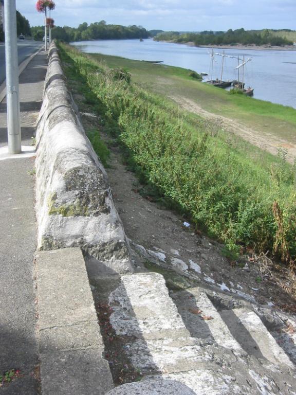 Parapet en pierre bordant le haut du perré.
