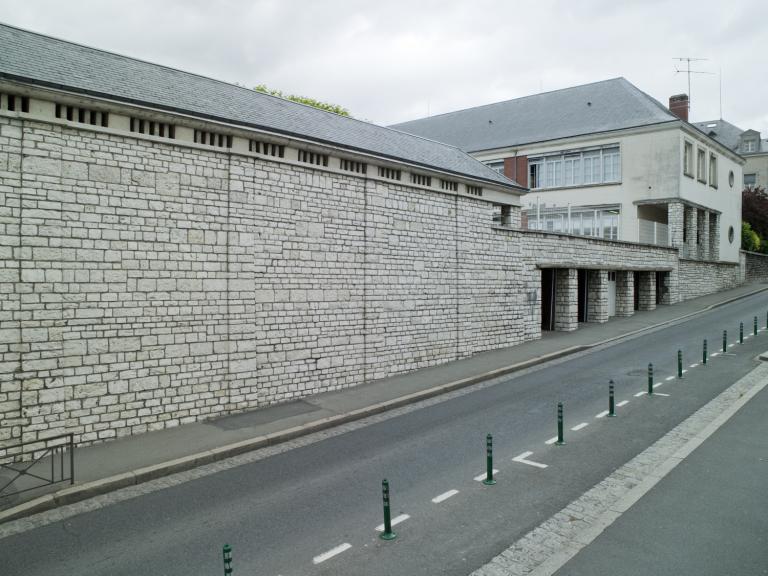 Vue depuis la rue Trouessard. Mur de soubassement et garages.