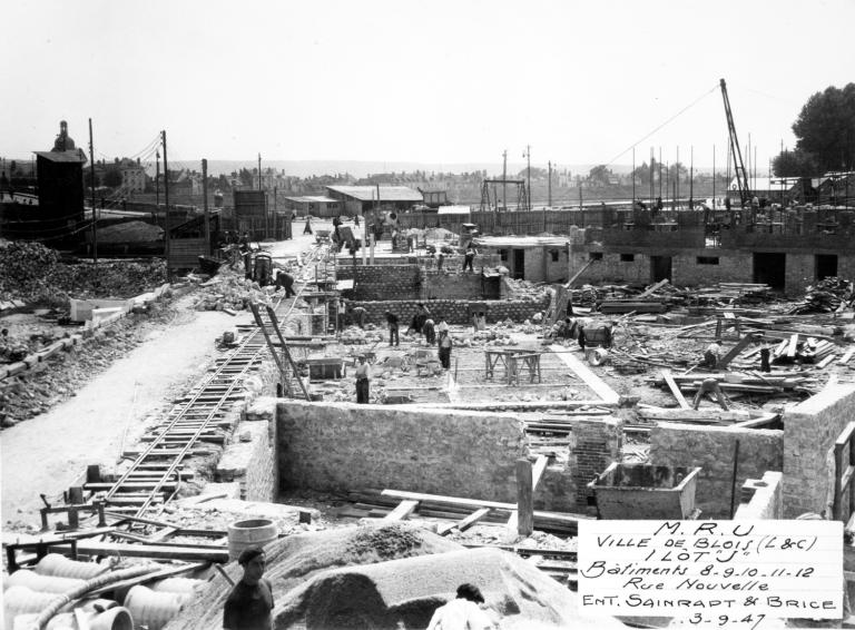 Au premier plan, construction du niveau de sous-sol de l'immeuble, 03-09-1947. (Archives départementales de Loir-et-Cher, Blois, 1195 W 44). ; Immeubles de la rue Henry-Drussy, construction des murs du sous-sol en maçonnerie de moellon, 3-09-1947.  (Archives départementales de Loir-et-Cher, Blois, 1195 W 44).