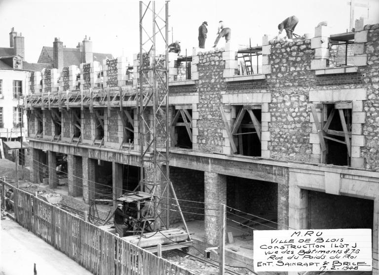 Montage en cours des murs du deuxième étage en pierre de taille avec moellon en remplissage, 02-1948. (Archives départementales de Loir-et-Cher, Blois, 1195 W 44). ; Montage en cours des murs du deuxième étage en pierre de taille avec moellon en remplissage, îlot J, 02-1948. (Archives départementales de Loir-et-Cher, Blois, 1195 W 44). ; Immeubles de la rue du Poids-du-Roi, on monte les murs et les baies du 2e étage, 02-1948. (Archives départementales de Loir-et-Cher, Blois, 1195 W 44).