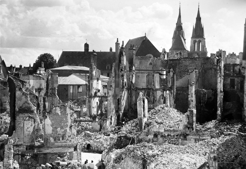 Ruines, au fond la couverture du Théâtre et de l'église Saint-Nicolas, été 1940. (Archives départementales de Loir-et-Cher, Blois, 127 J 70).