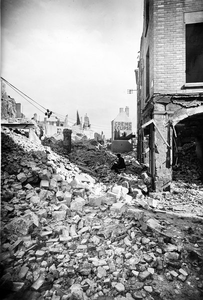 Ruines rue du Vieux pont, au coin de la rue des Orfèvres, au premier plan, Etienne Gaudet dessine les ruines, été 1940. (Archives départementales de Loir-et-Cher, Blois, 127 J 70).