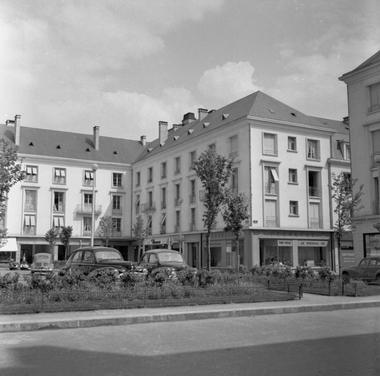 Vue des façades de l'îlot M sur la place, mai 1954. (ministère de l'écologie, du développement durable, des transports et du logement, Fonds M.R.U., cliché n°20381). ; Vue des façades donnant sur la place de la Résistance, 1954. (ministère de l'écologie, du développement durable, des transports et du logement, Fonds M.R.U., cliché n°20381).