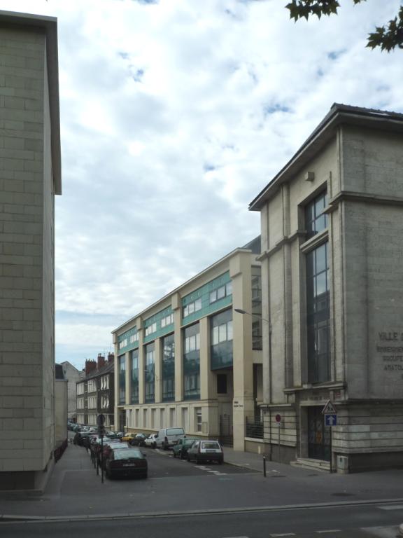Bâtiments du groupe scolaire alignés sur la rue des Amandiers, vus depuis le quai. ; Façade principale du collège rue des Amandiers, vue depuis le quai.