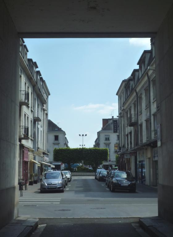 Rue des Fusillés, vue depuis le porche monumental de l'îlot du Commerce. ; Place de la Résistance dans l'axe de la rue des Fusillés, vue depuis le porche monumental.